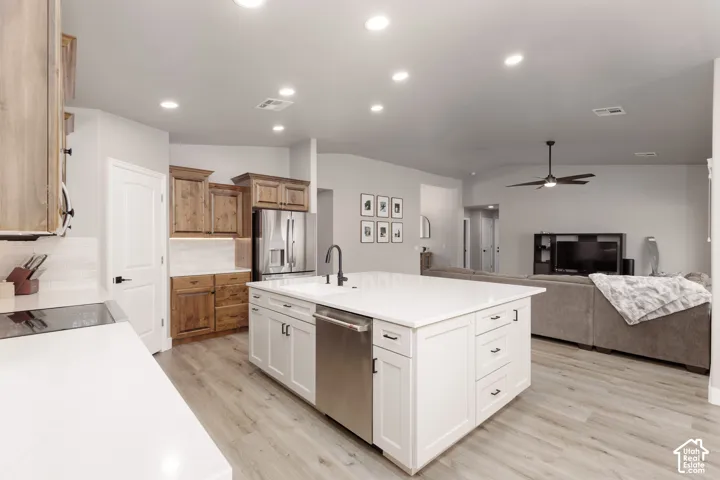 Modern kitchen featuring a large central island with white cabinetry and a built-in stainless steel dishwasher