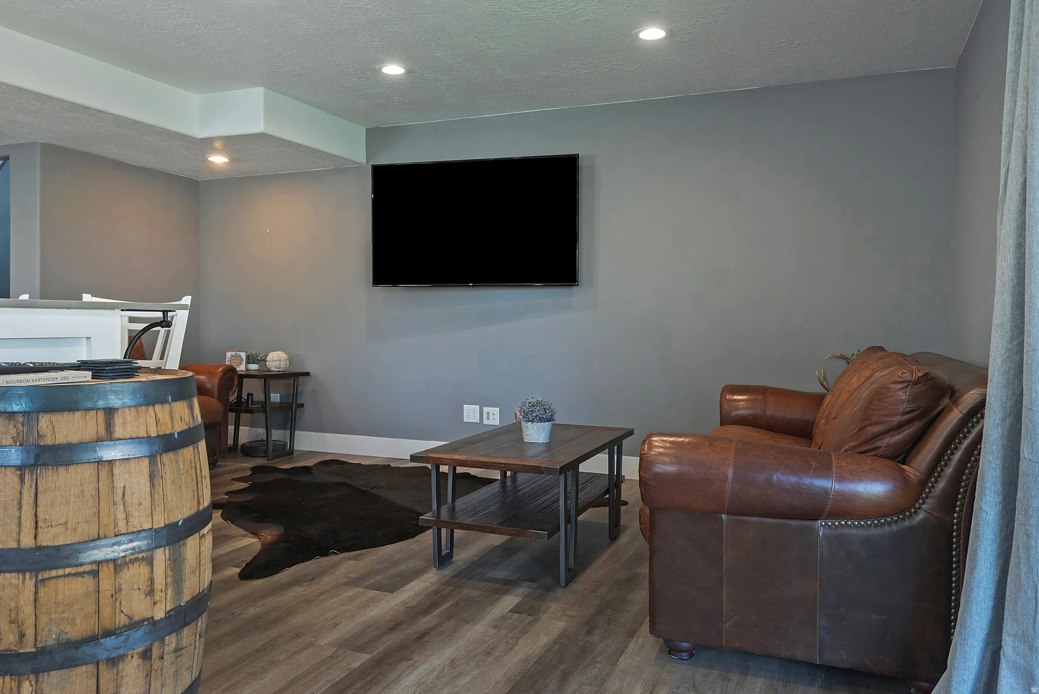 Entertainment space with recessed lighting and wood-finish flooring