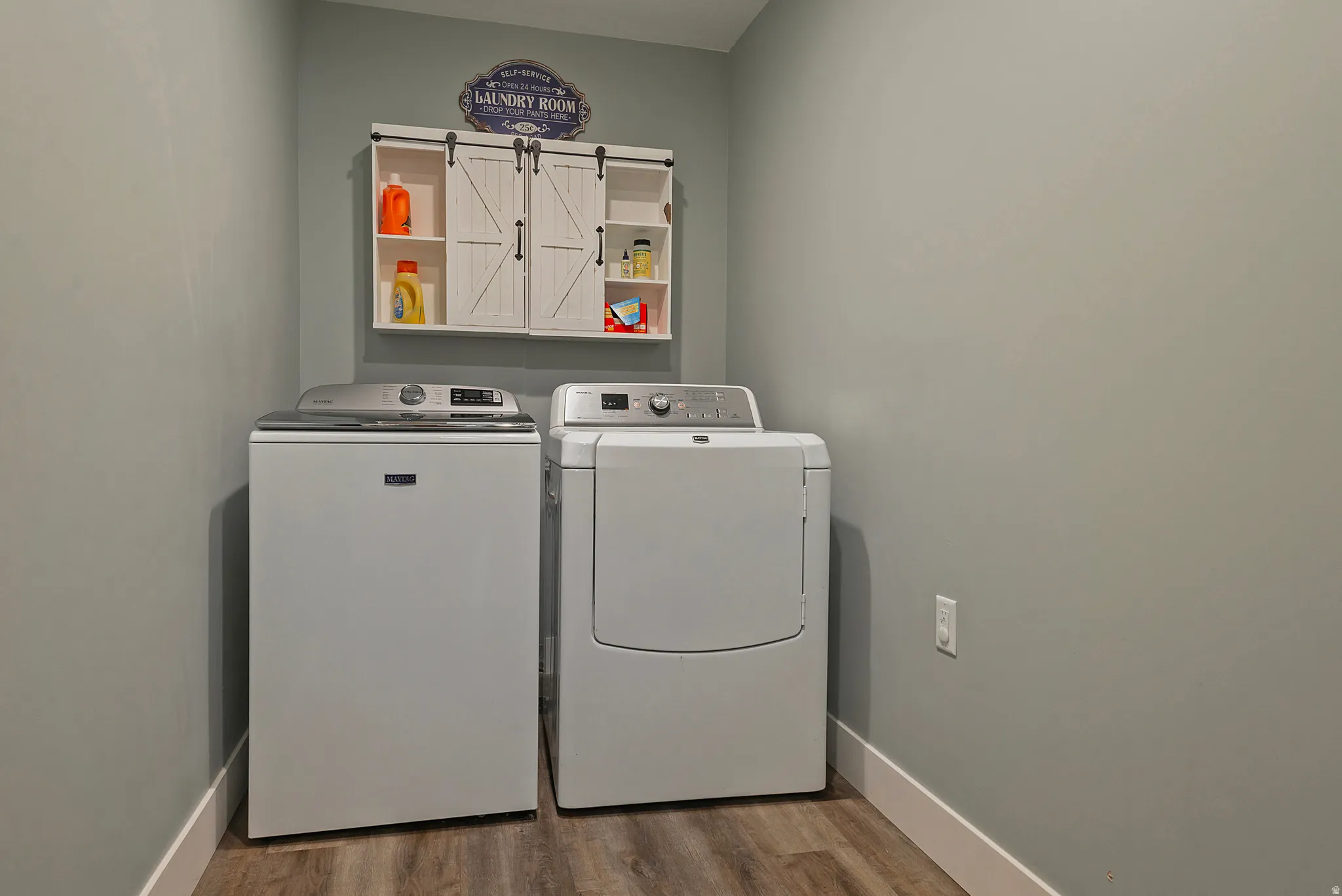 Dedicated laundry area featuring wood-finish flooring and light gray walls
