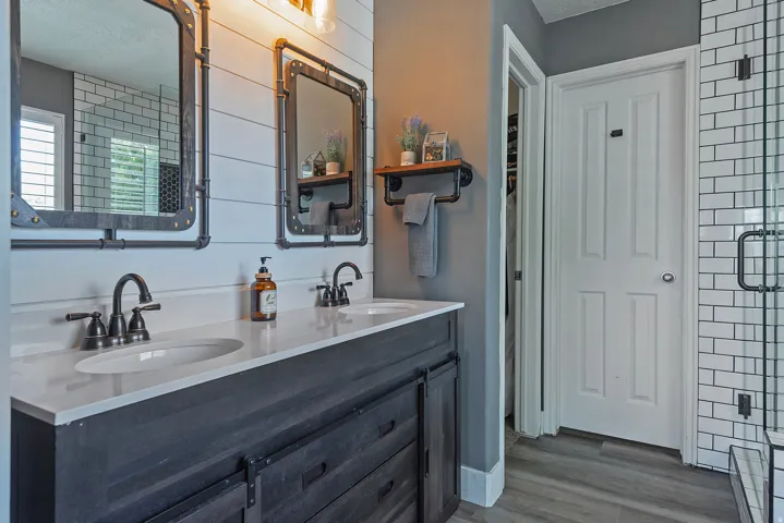 Dual vanity with dark wood-finish cabinetry, white countertop, and matte black fixtures