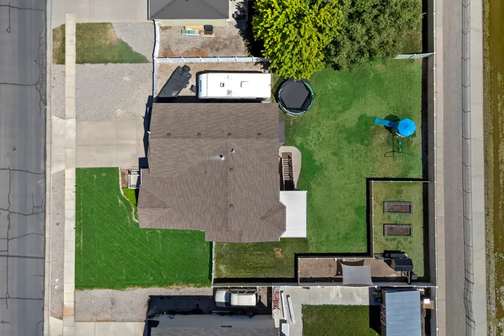 Expansive property featuring a large landscaped yard, paved driveway, dedicated RV parking, and two raised garden beds