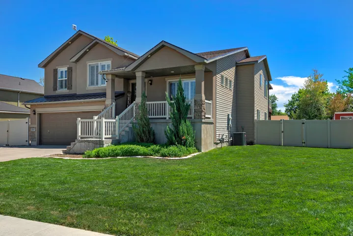 Two-story property featuring a stucco and siding exterior, an attached garage, and a covered porch