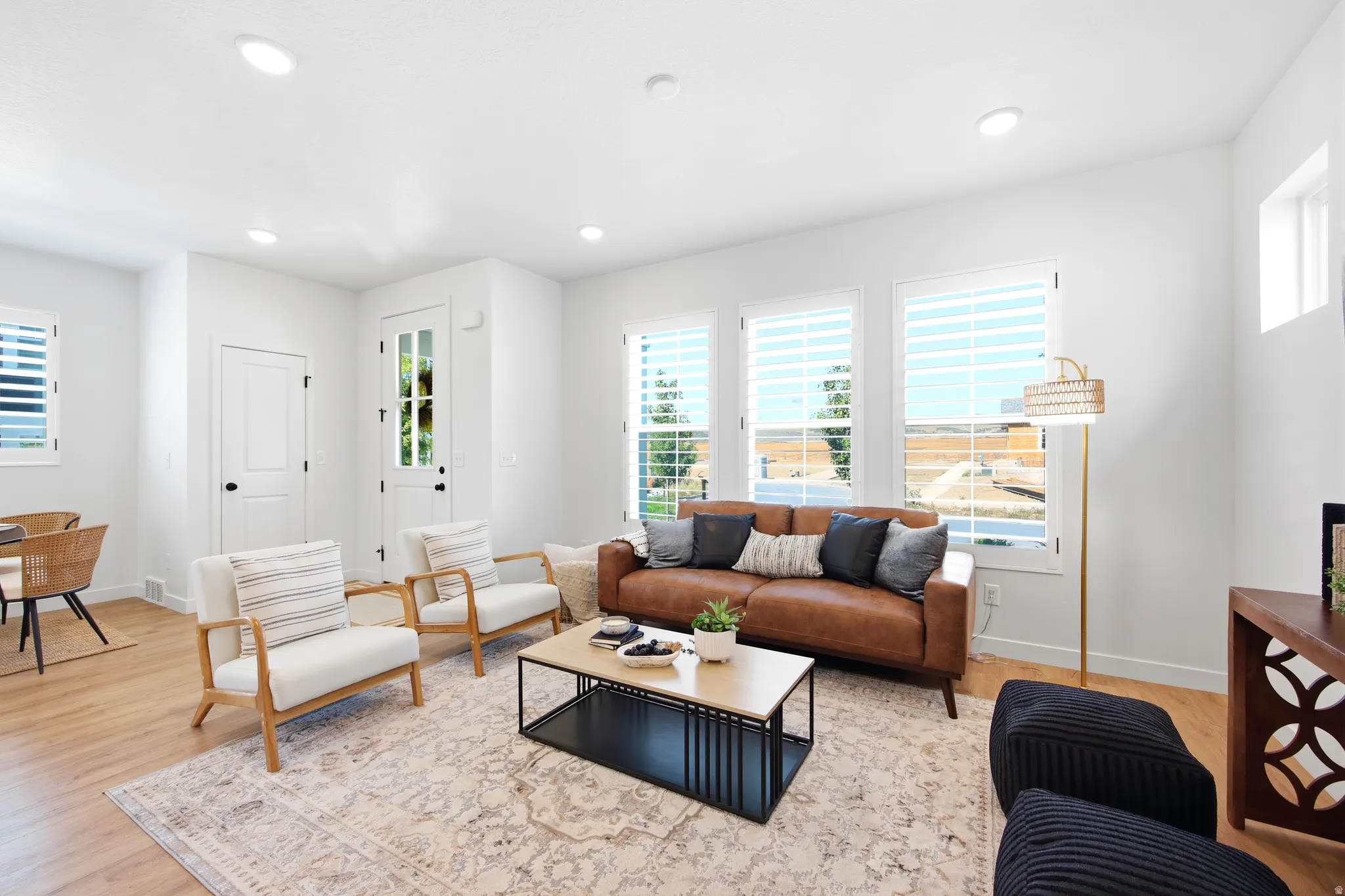 Bright living area featuring wood-finish flooring, recessed lighting, and white walls