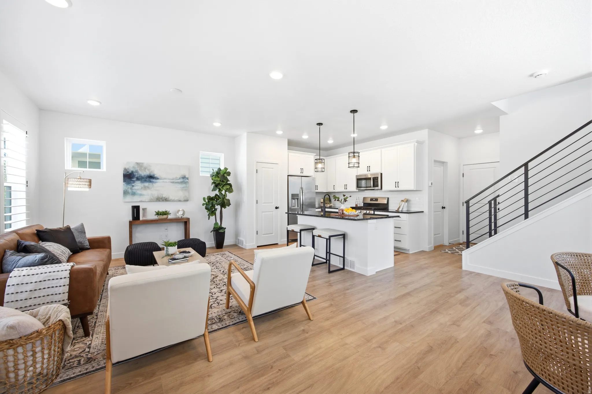 Open-concept living space featuring wood-finish flooring, recessed lighting, and white walls