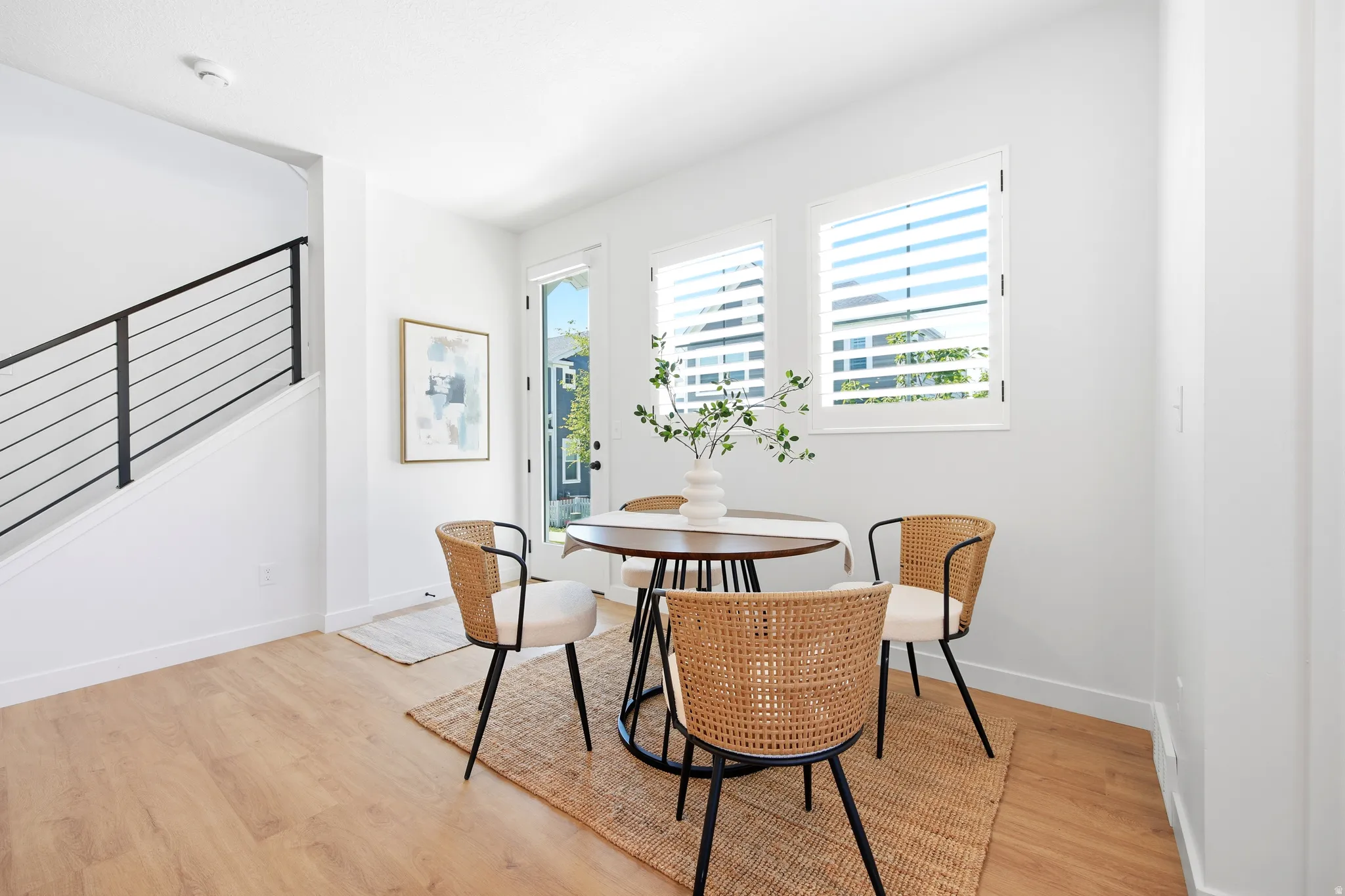 White interior walls featuring light wood-finish flooring