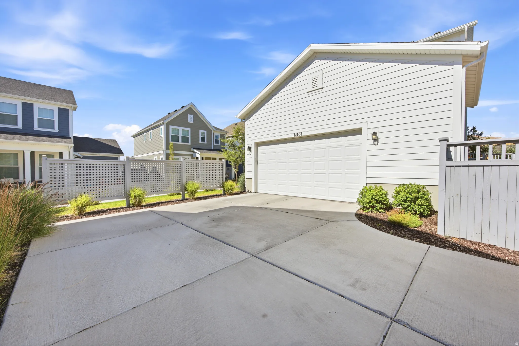 Concrete driveway leading to a two-car garage with white siding