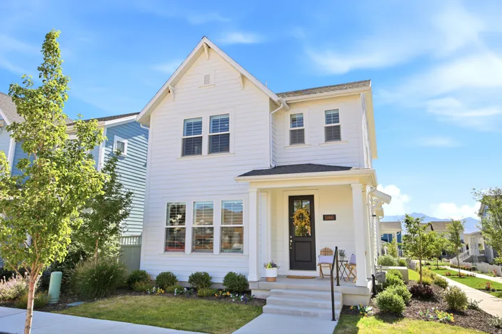 Two-story white siding exterior with a dark front door and covered porch