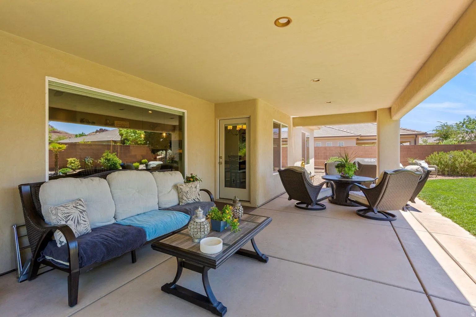 Expansive covered patio featuring a concrete surface, recessed lighting, a large picture window, and direct access to the backyard