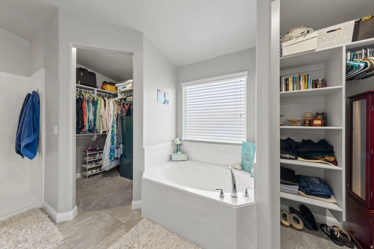 Corner soaking tub with a three-piece faucet set and window with blinds