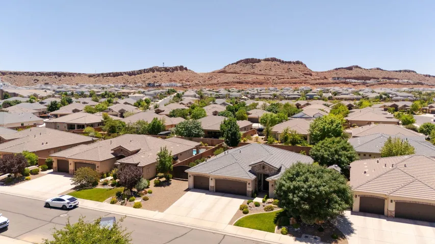 Residential neighborhood featuring a variety of single-story homes with tile roofs, mature landscaping, and an arid mountain backdrop