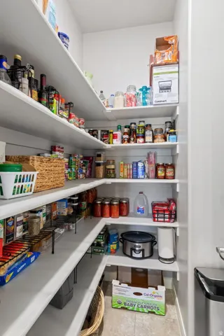 Spacious pantry featuring multiple tiers of white shelving