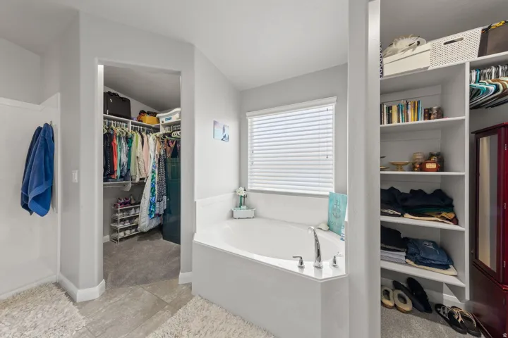 Corner soaking tub with a three-piece faucet set and window with blinds