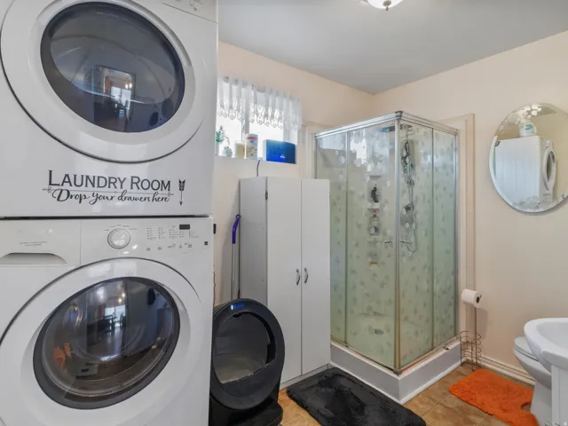 Integrated laundry area featuring stacked appliances