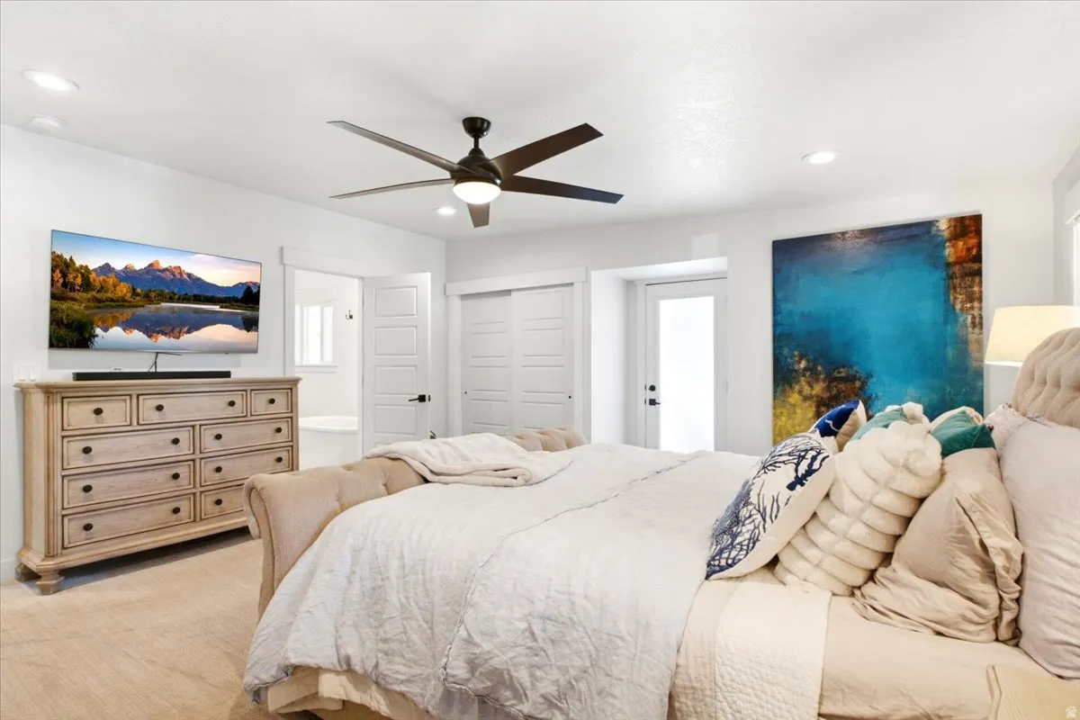 Spacious room featuring light-toned wood-finish flooring and a ceiling fan with integrated lighting