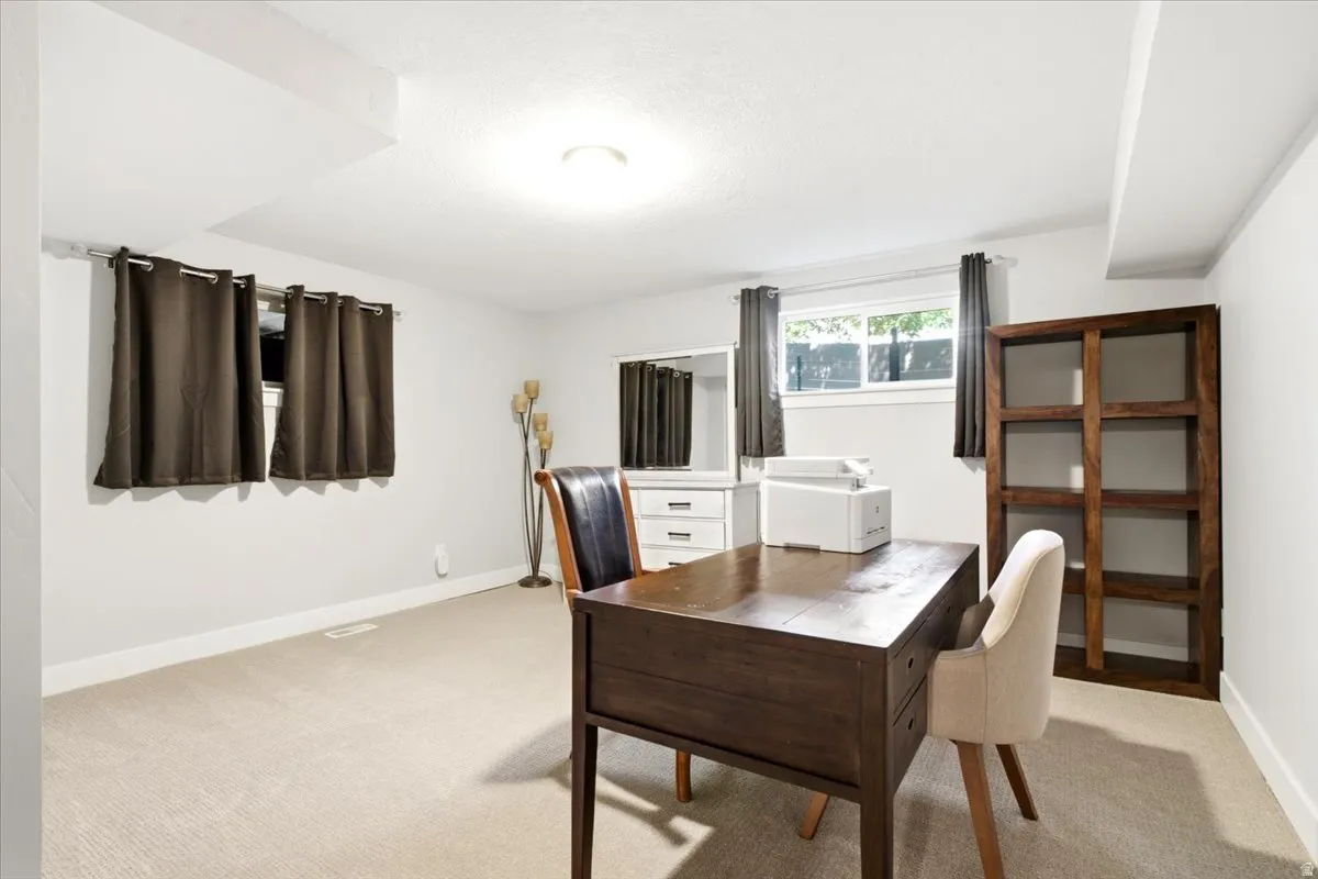 Spacious room featuring neutral carpeting, light-toned walls, and recessed lighting