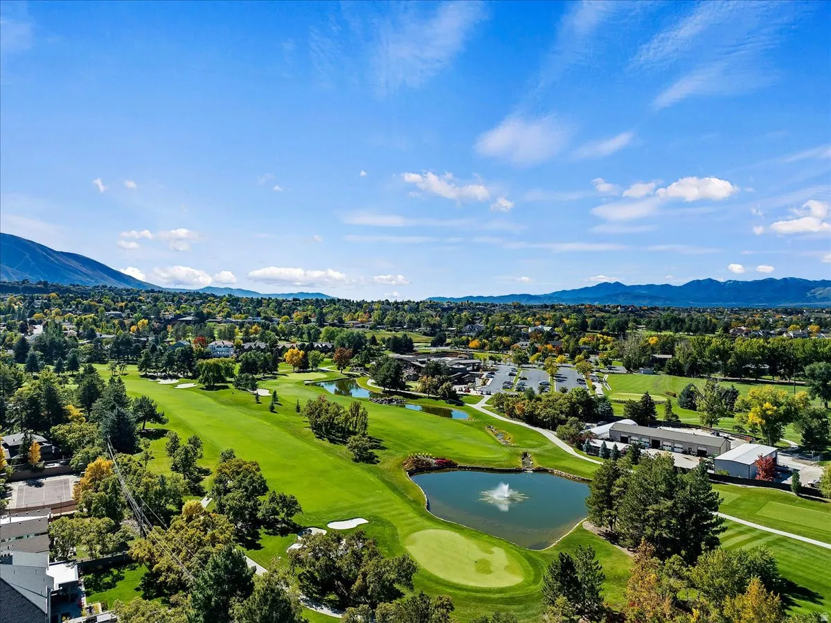 Expansive golf course with manicured greens and a central pond featuring a fountain