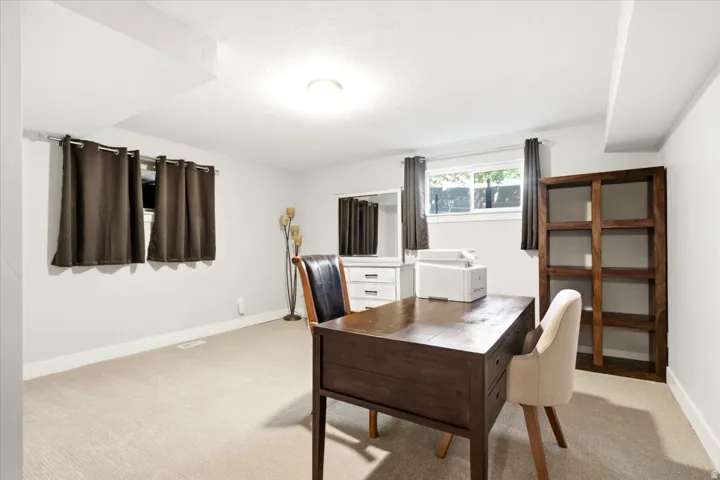 Spacious room featuring neutral carpeting, light-toned walls, and recessed lighting