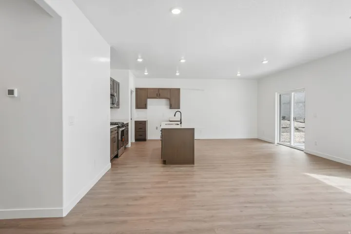 Open-concept living area featuring wood-finish flooring, recessed lighting, and white walls