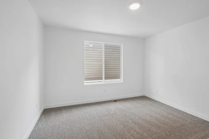 Neutral-toned walls complement the gray carpeting
