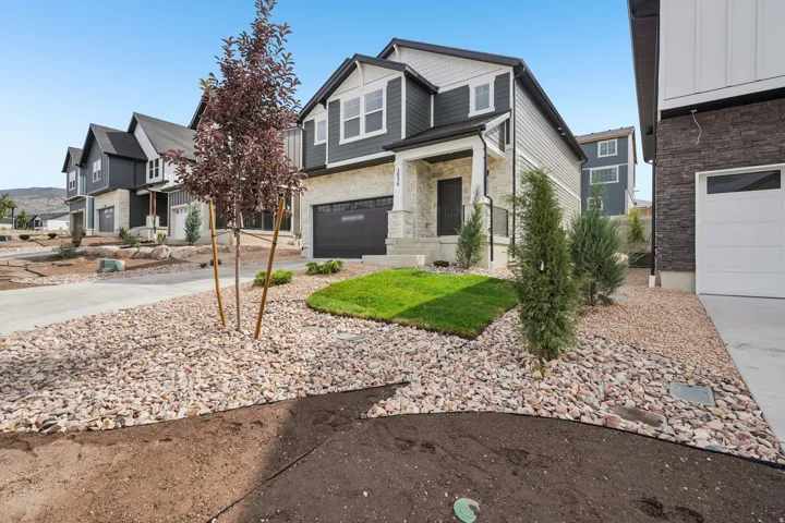 Contemporary two-story exterior with dark siding and light stone accents