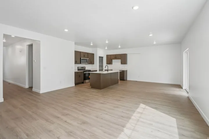 Open-concept living space featuring wood-finish flooring, recessed lighting, and a modern kitchen