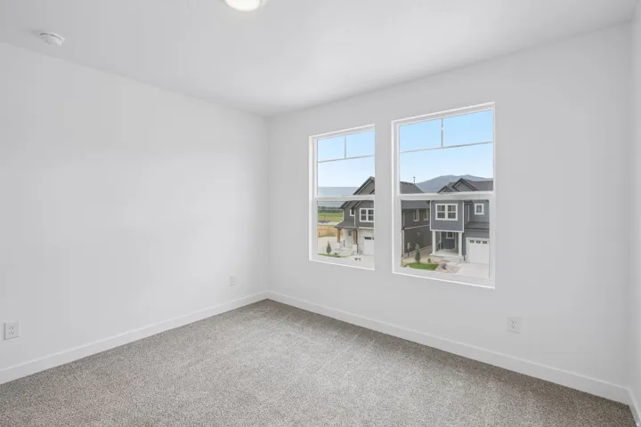 Bright interior space with dual windows, neutral wall color, and carpeted flooring
