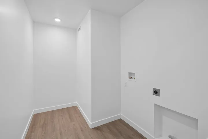 Utility room with wood-finish flooring, recessed lighting, and white walls