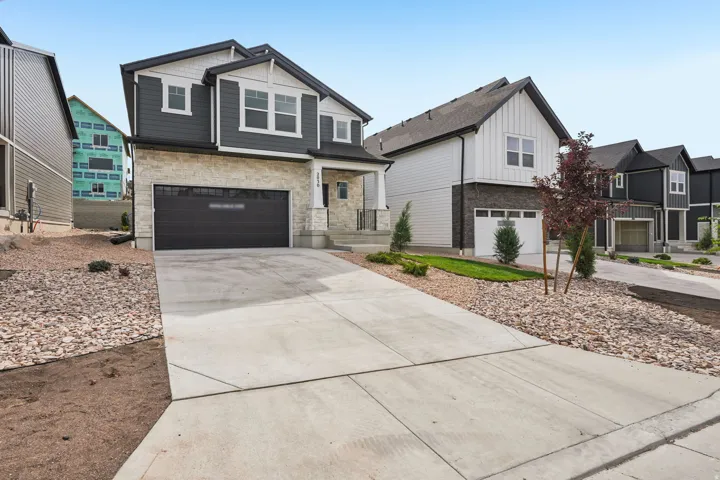 Modern two-story exterior with stone and siding facade, covered entry, and integrated two-car garage