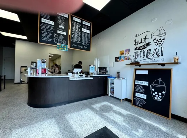 Commercial interior featuring a service counter with a light-colored countertop and dark wood-finish base