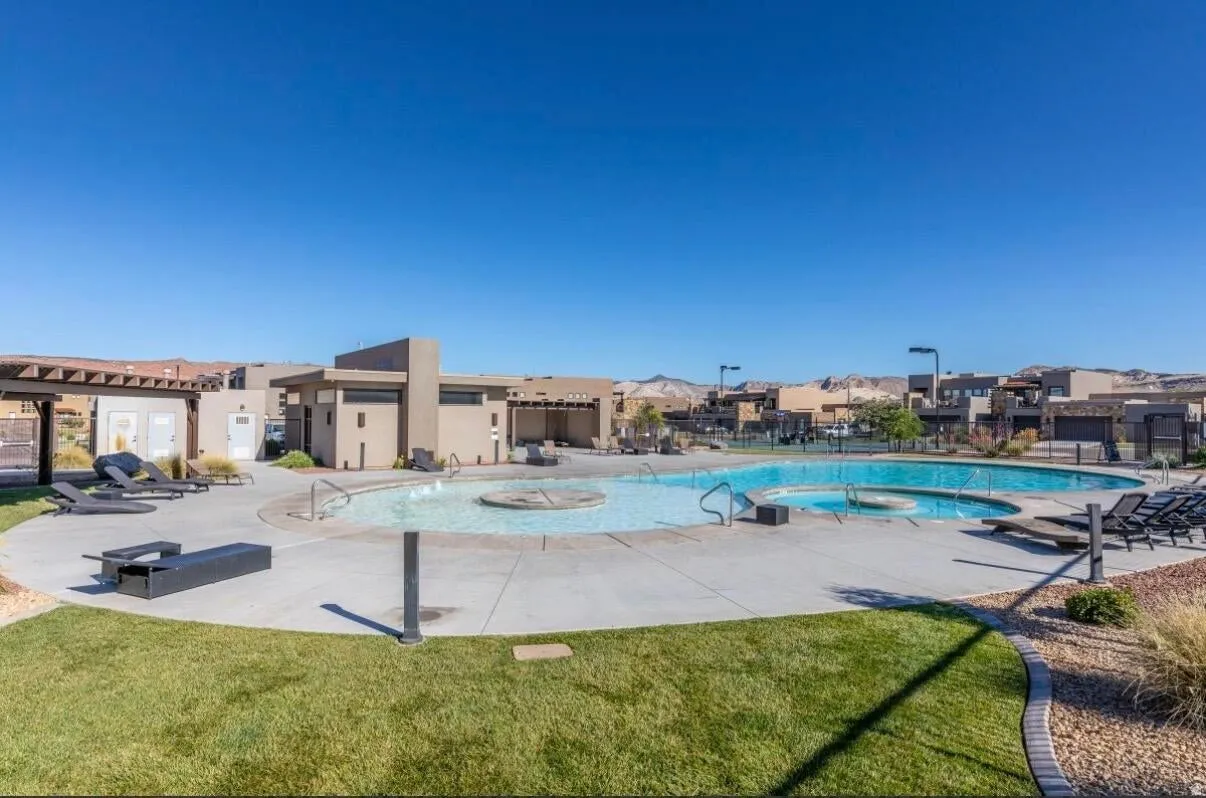 Expansive outdoor swimming pool with integrated spa and surrounding concrete decking