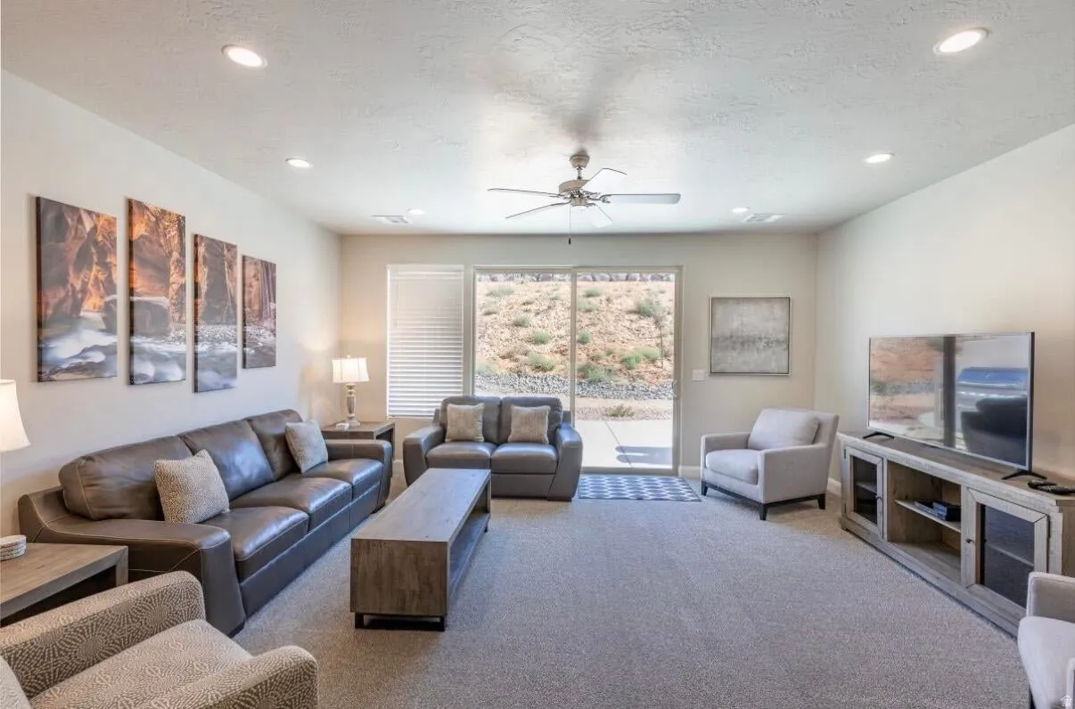 Carpeted living space with recessed lighting and a ceiling fan