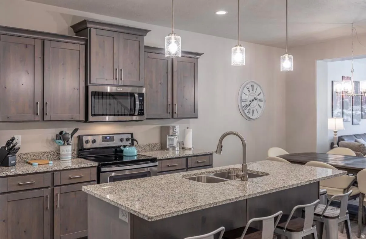 Kitchen featuring wood-finish cabinetry, stainless steel appliances, and granite countertops