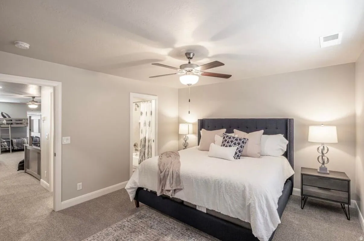 Carpeted bedroom featuring a ceiling fan with integrated lighting, recessed lighting, and a doorway to an additional room