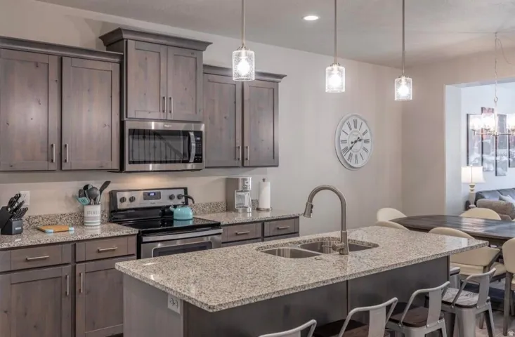 Kitchen featuring wood-finish cabinetry, stainless steel appliances, and granite countertops