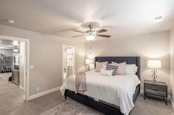 Carpeted bedroom featuring a ceiling fan with integrated lighting, recessed lighting, and a doorway to an additional room