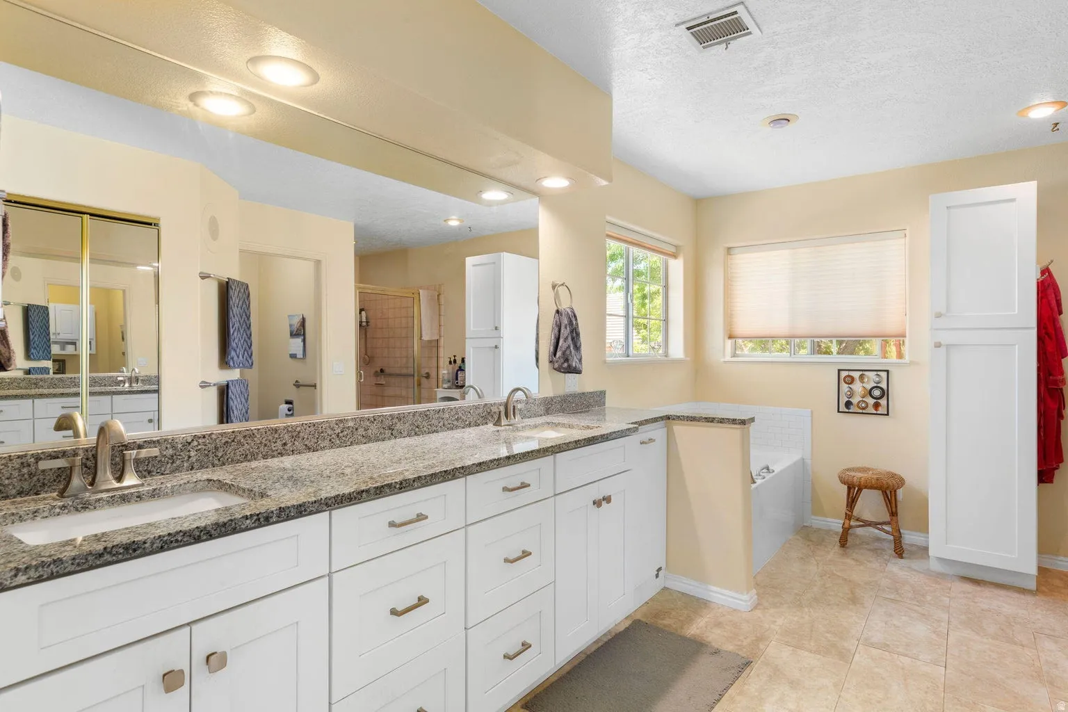 Dual vanity with granite countertops, shaker-style cabinetry, and brushed nickel fixtures