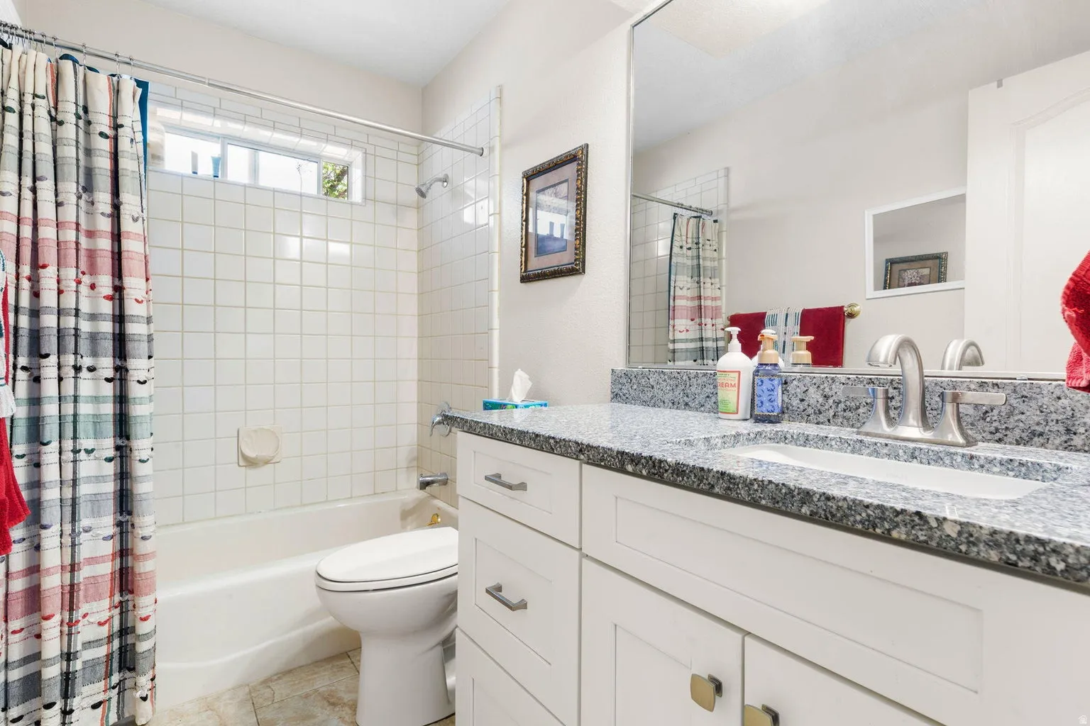 Bathroom featuring a white vanity with a speckled countertop, an integrated sink, and a large wall-mounted mirror