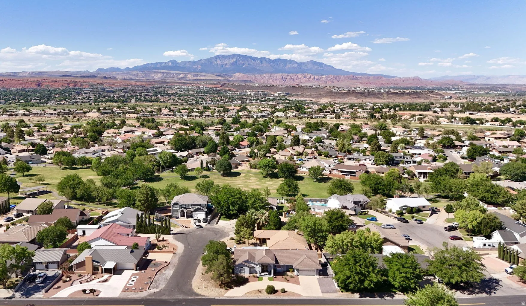 Aerial landscape showcasing a residential area with mature trees and visible mountain ranges