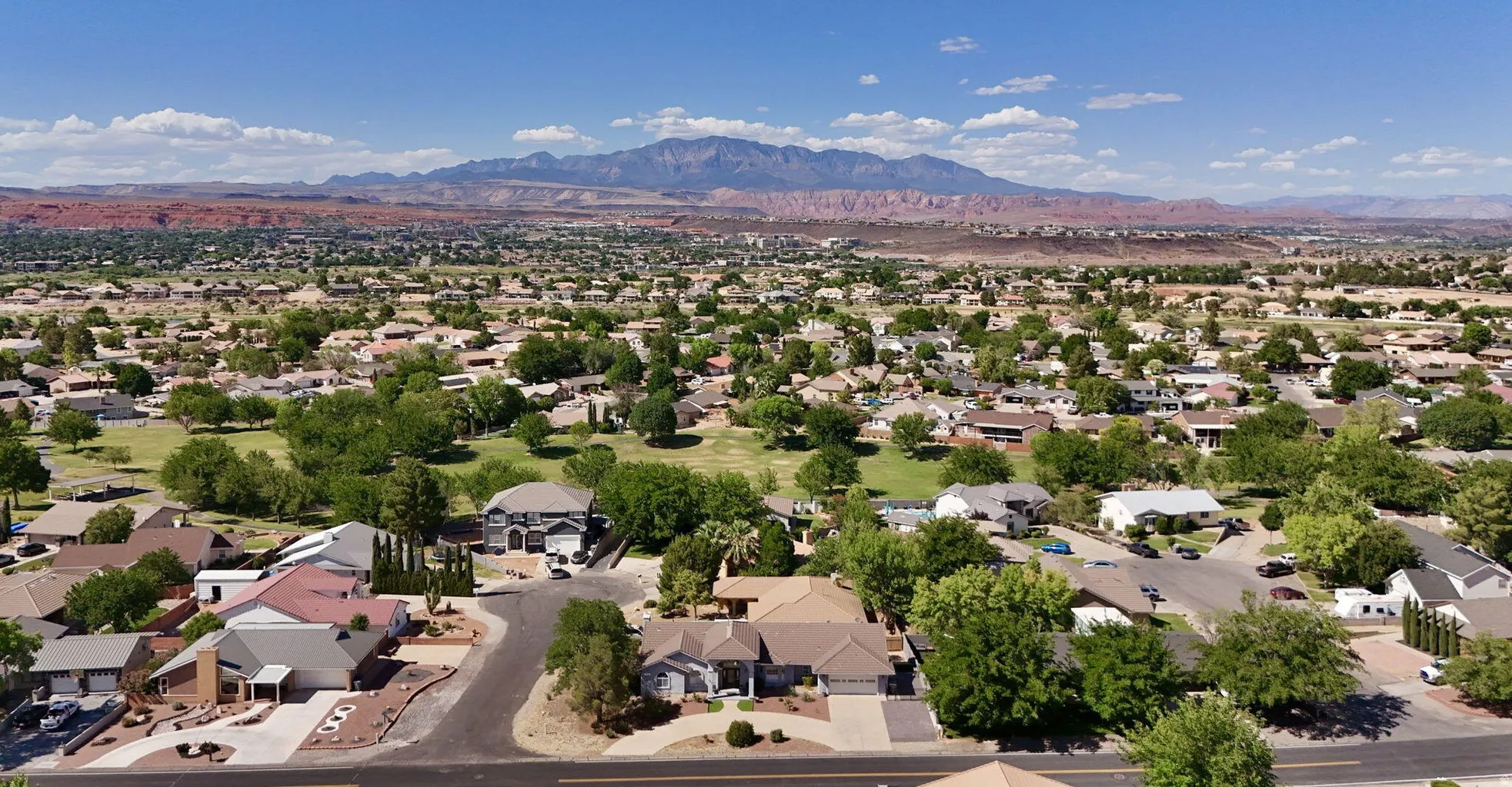 Expansive residential area featuring numerous single-story and two-story homes with diverse architectural styles, mature trees, and paved streets