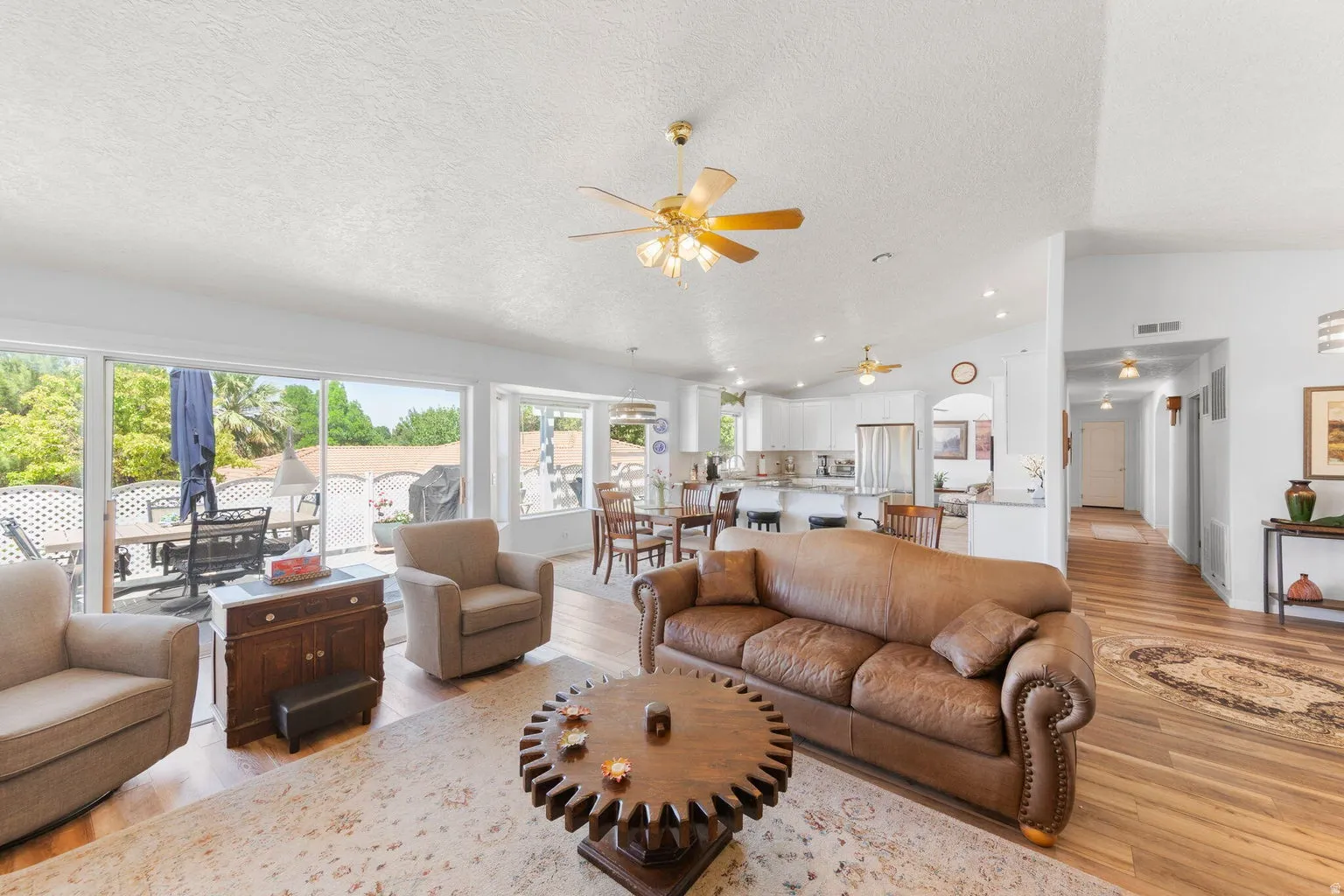 Open-concept living area featuring wood-finish flooring, recessed lighting, and vaulted ceilings