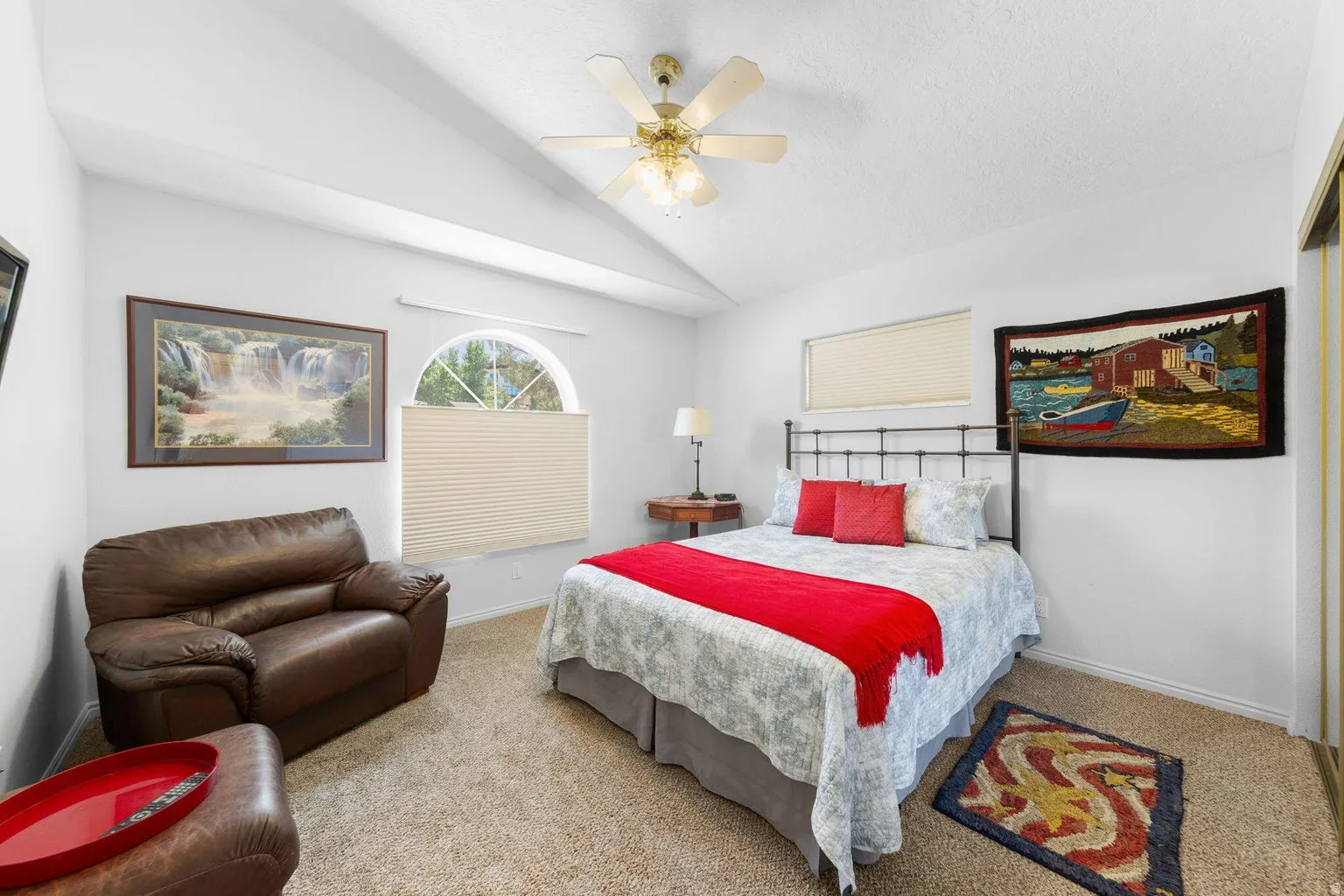 Bedroom featuring vaulted ceilings with exposed beams, a ceiling fan with integrated lighting, and carpet flooring