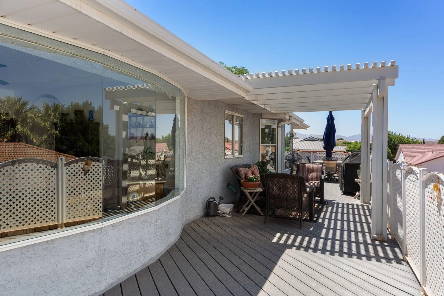 Expansive outdoor deck featuring composite decking and a white pergola