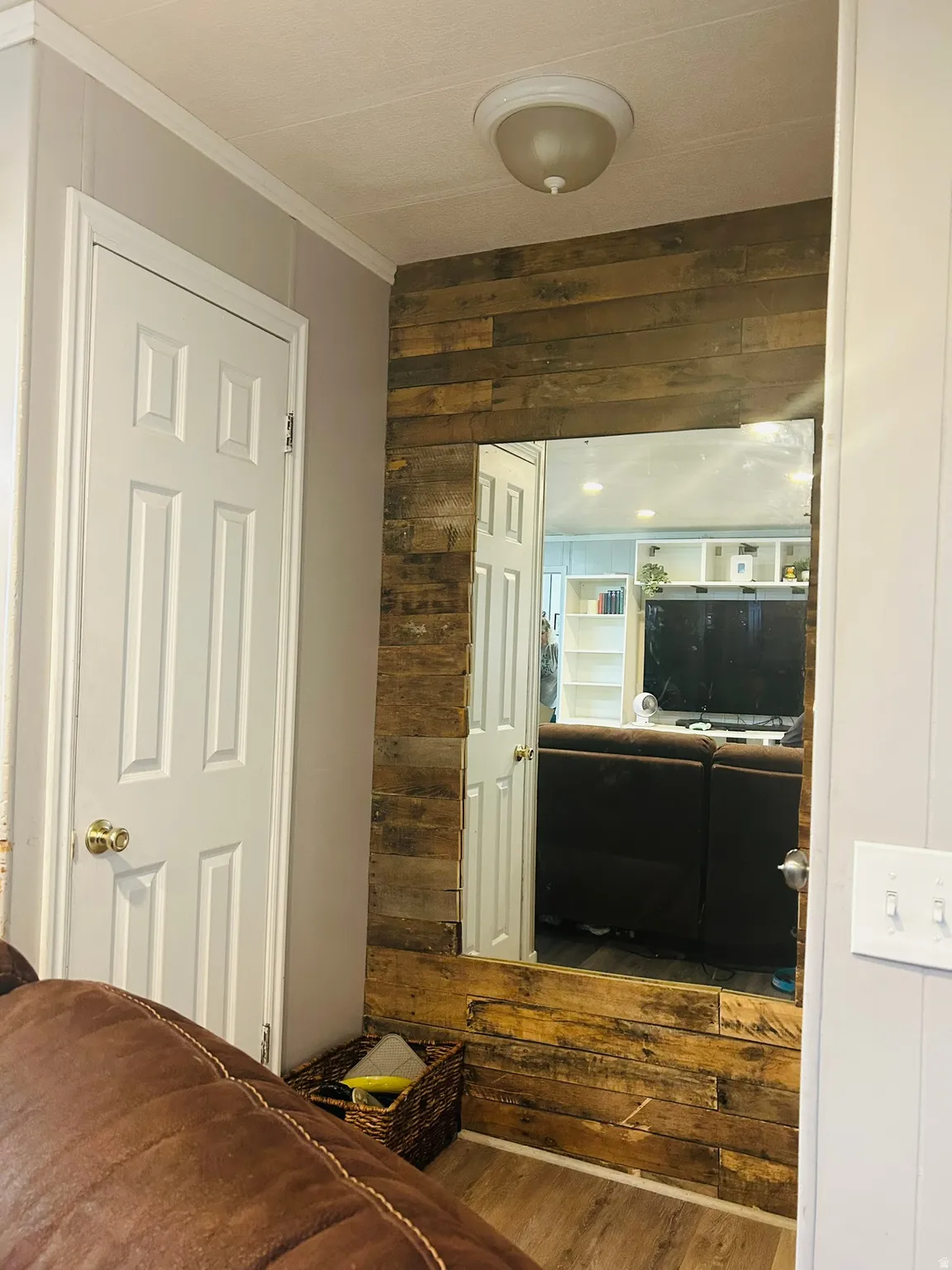 Accent wall featuring horizontal wood planks and a large recessed mirror