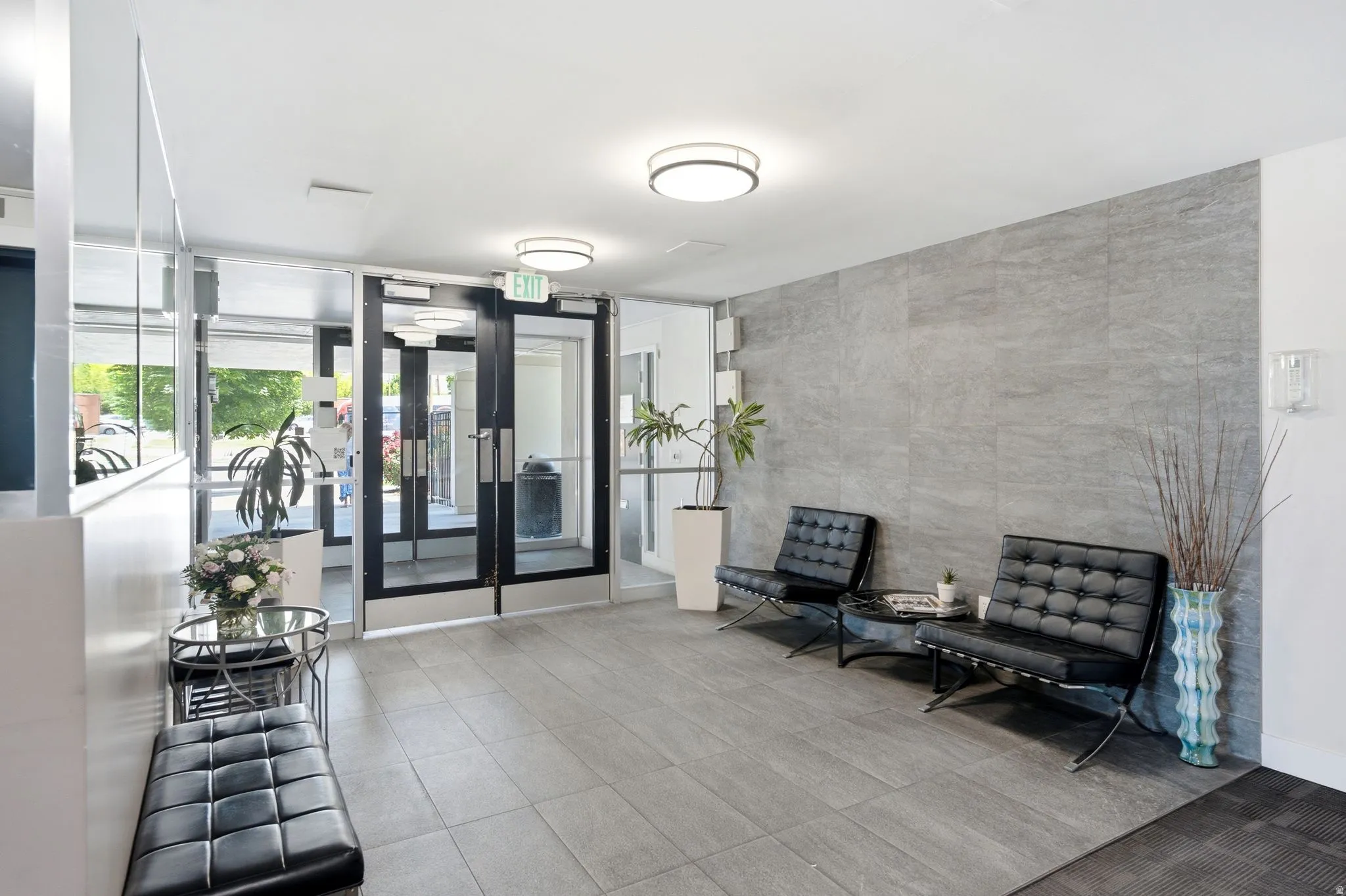 Lobby area featuring large format tile flooring and a textured accent wall