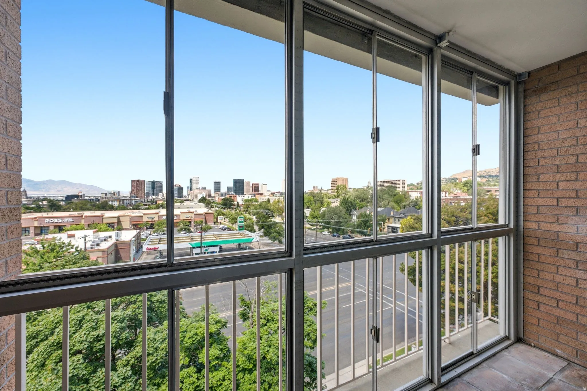 Enclosed balcony with expansive city and mountain scenery