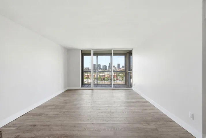 Spacious room featuring light wood-finish flooring and white baseboards