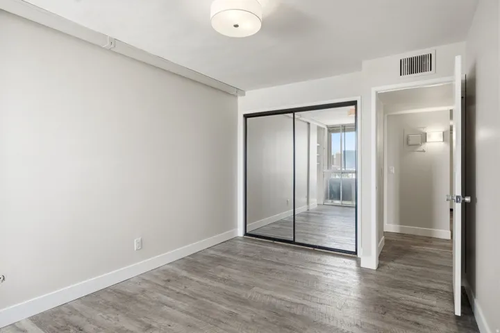Room featuring wood-finish flooring, light grey wall paint, and white baseboards