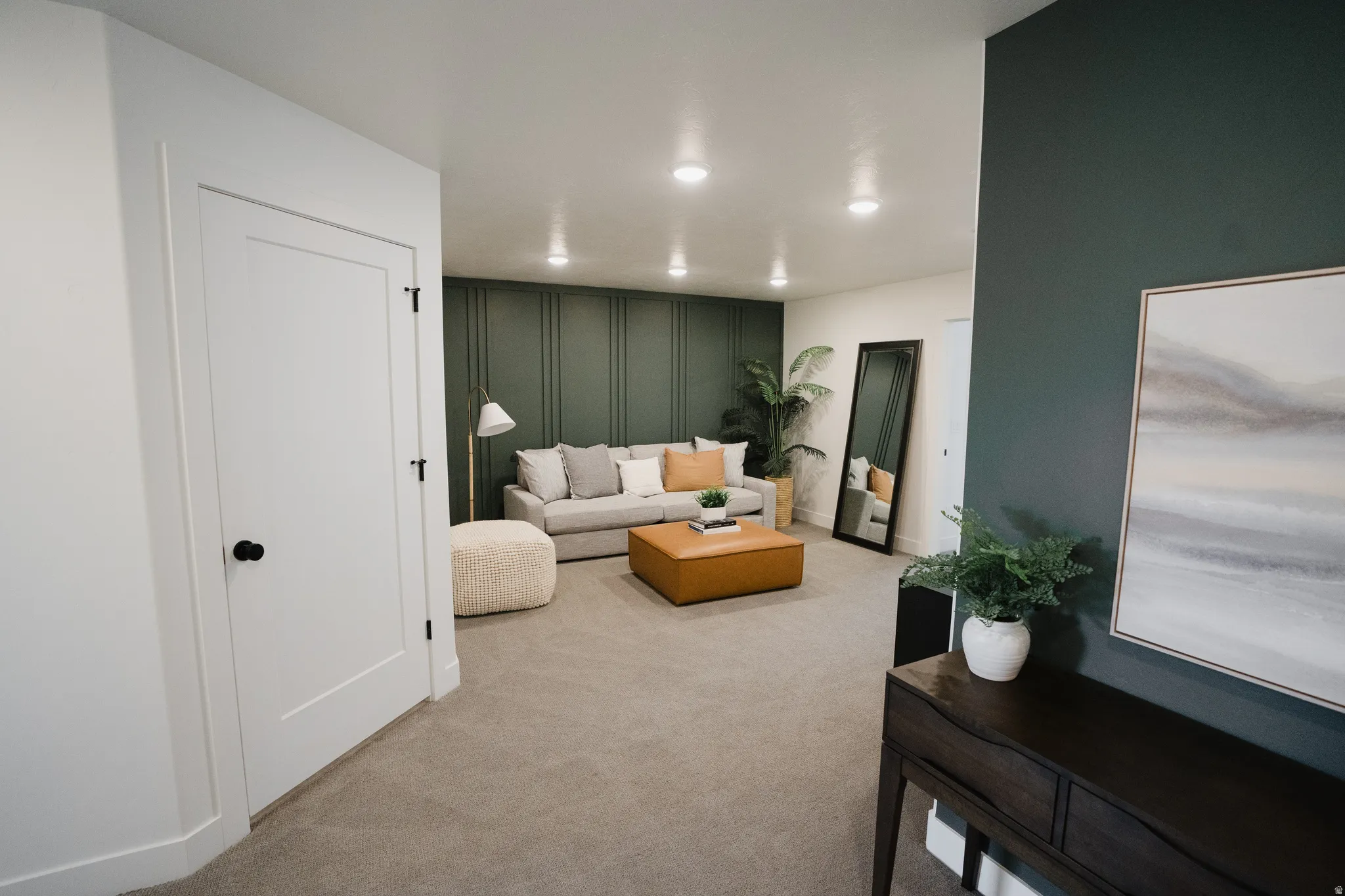 Carpeted living space featuring recessed lighting and a decorative accent wall