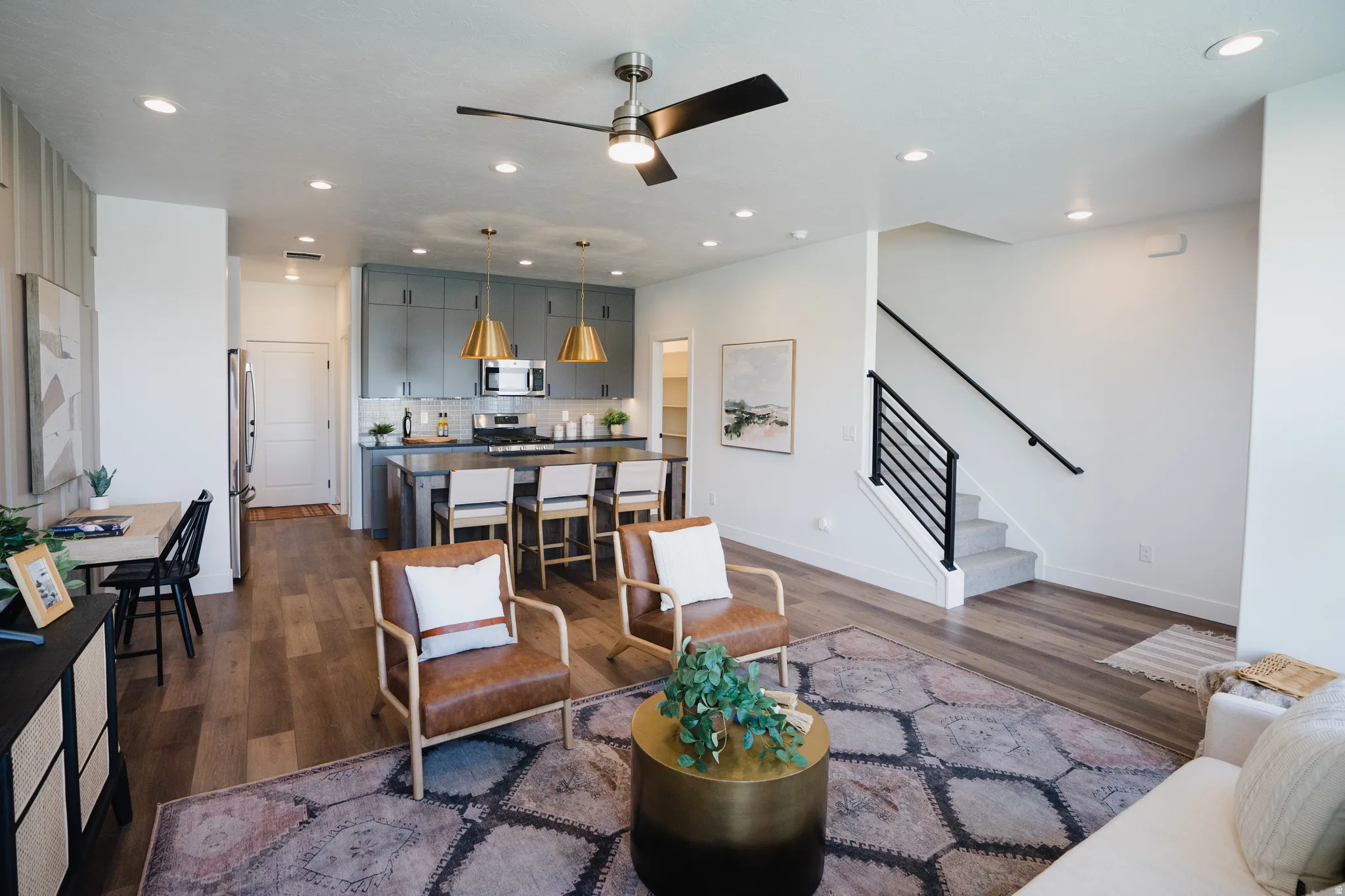 Open-concept living space featuring wood-finish flooring, recessed lighting, and a modern ceiling fan