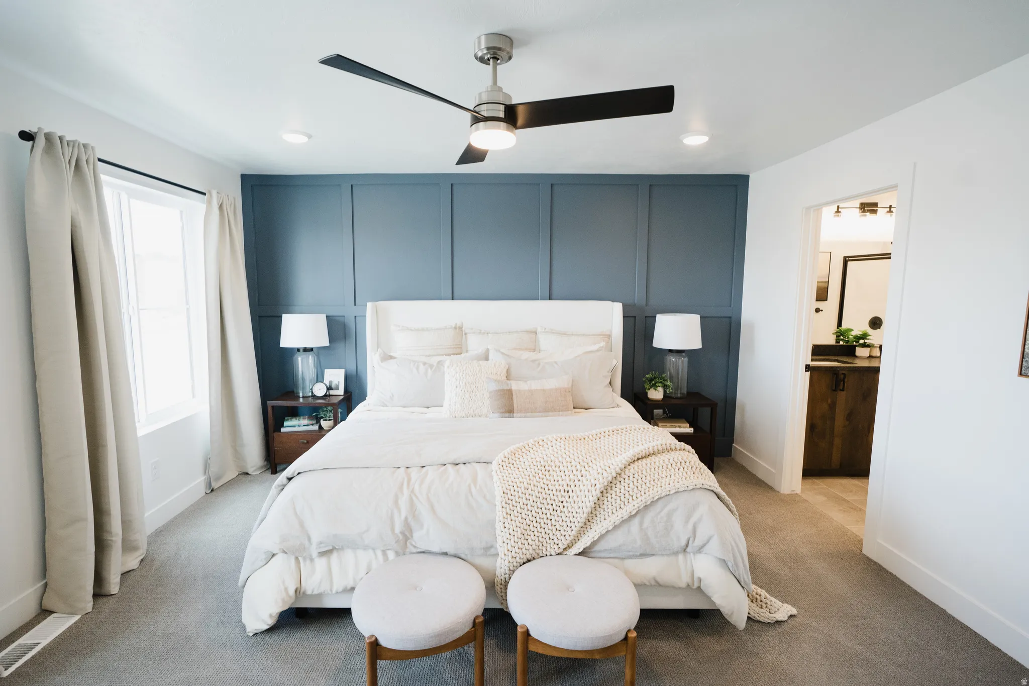 Bedroom featuring a feature wall with decorative paneling, recessed lighting, and a ceiling fan with light